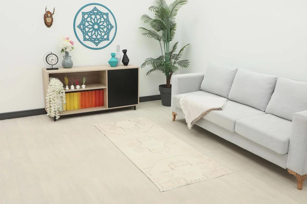 Ivory vintage runner in a modern living room setting with a light gray sofa and decorative cabinet
