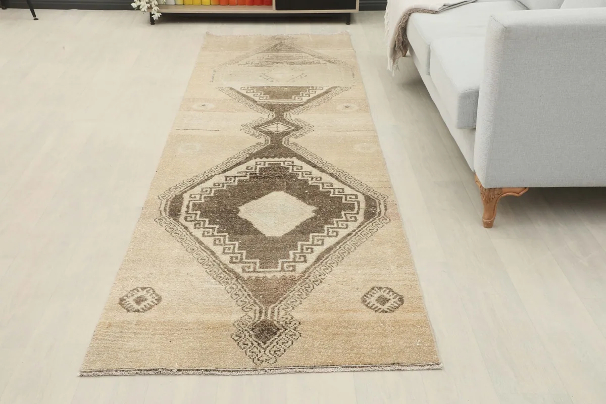 Full view of the runner rug laid out in a modern living space with a sofa and light flooring.