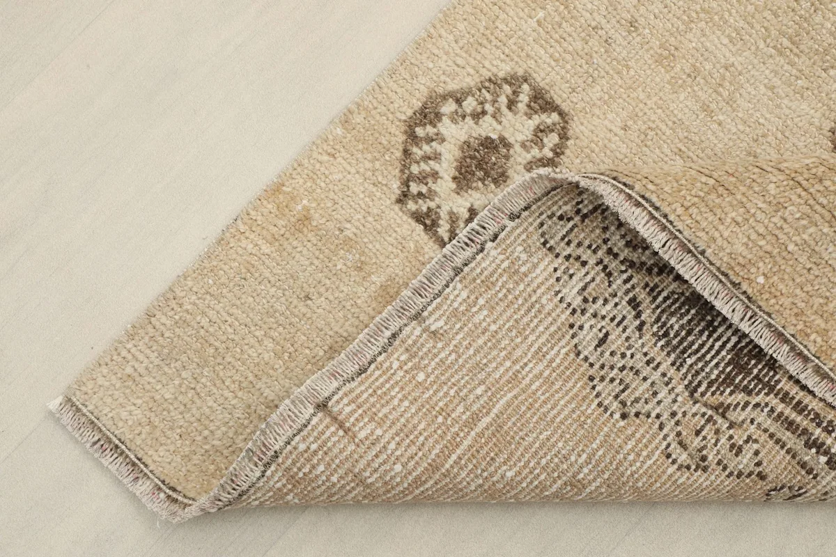 Corner of the runner folded to show the hand-knotted cotton foundation on the back.