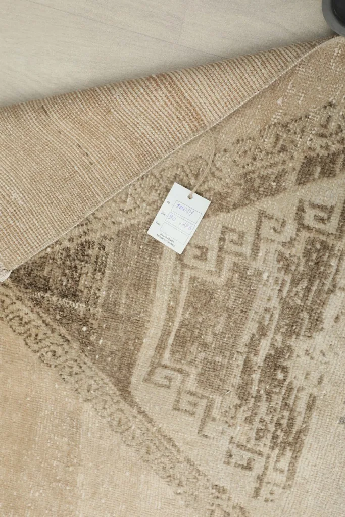 Reverse side of the runner rug with a tag, revealing the hand-knotted construction.