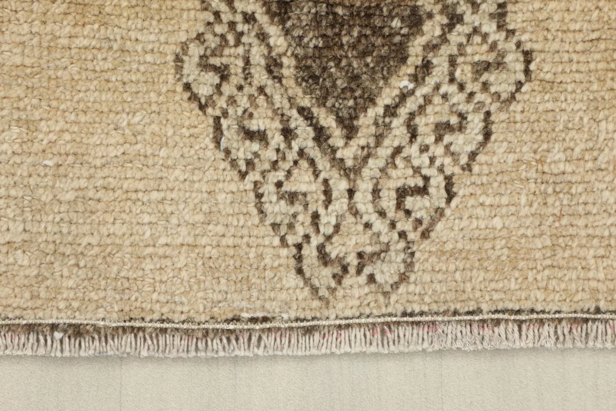 Close-up of the short, natural fringe and the finished edge of the vintage runner rug.