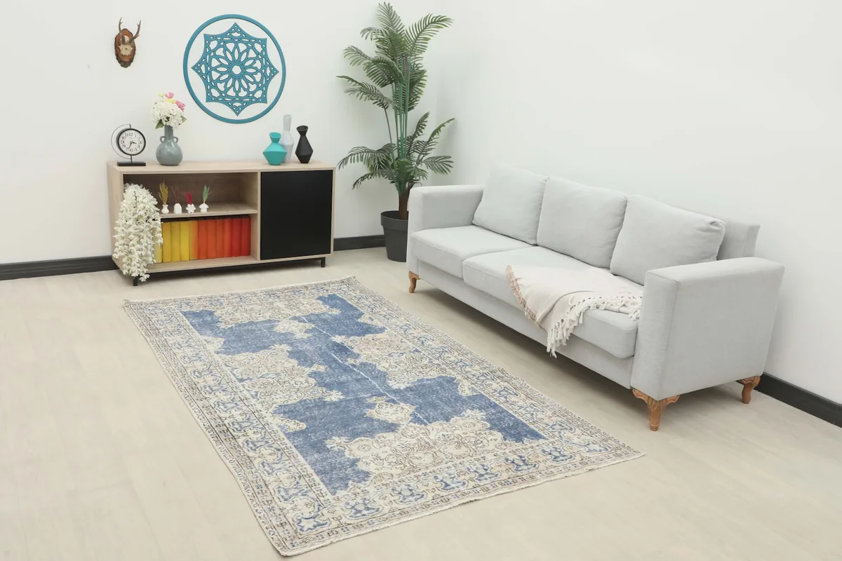 Blue vintage Anatolian rug in a living room setting with a light gray sofa