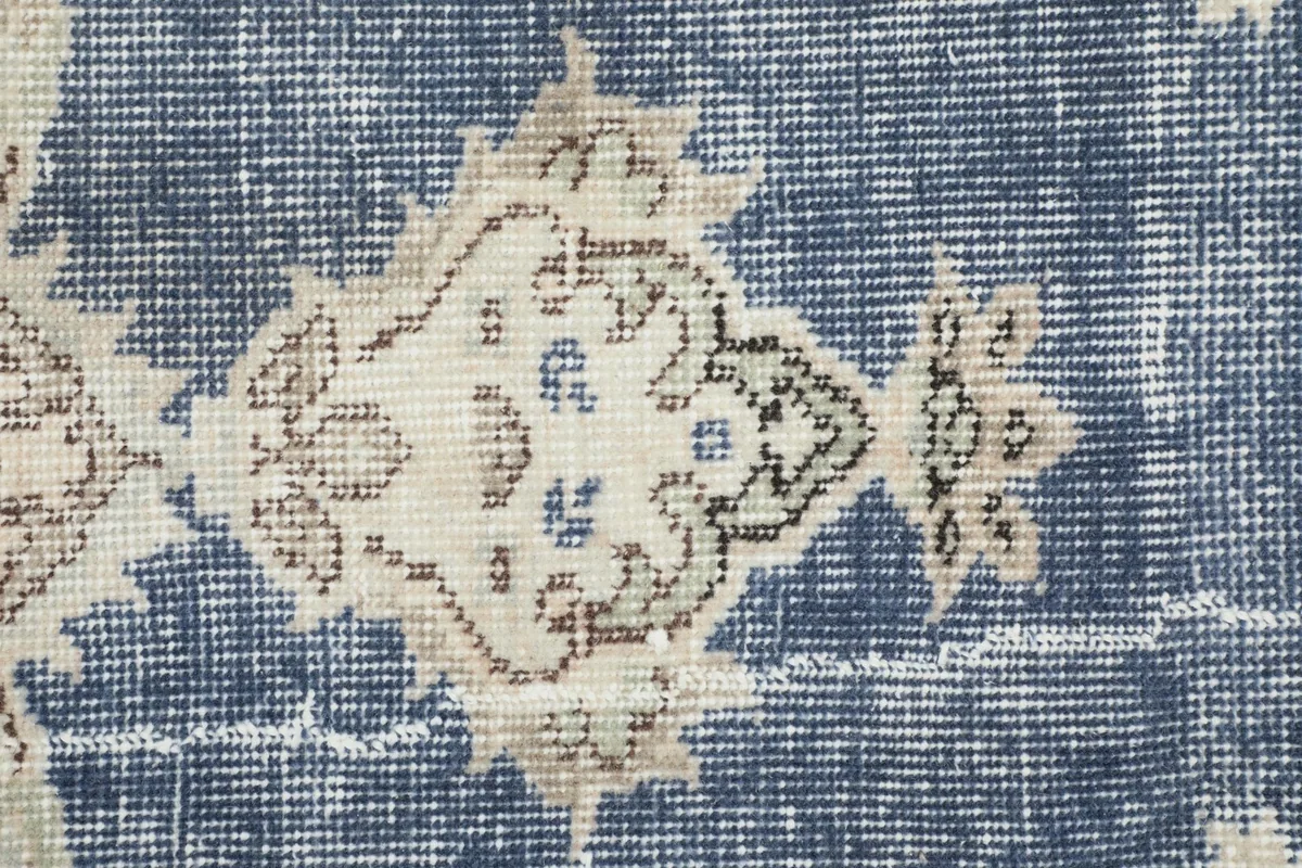 Detailed view of the wool pile and intricate cream and beige geometric patterns