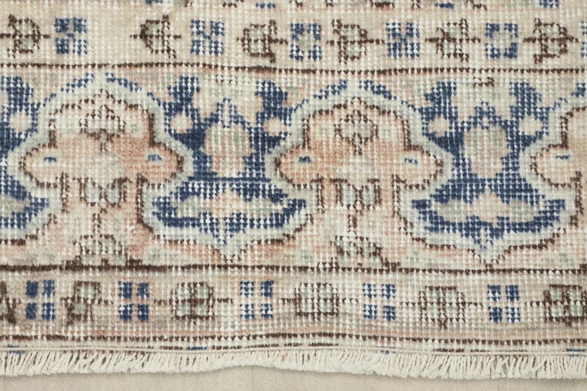 Close-up of the border design and short fringes of the vintage rug