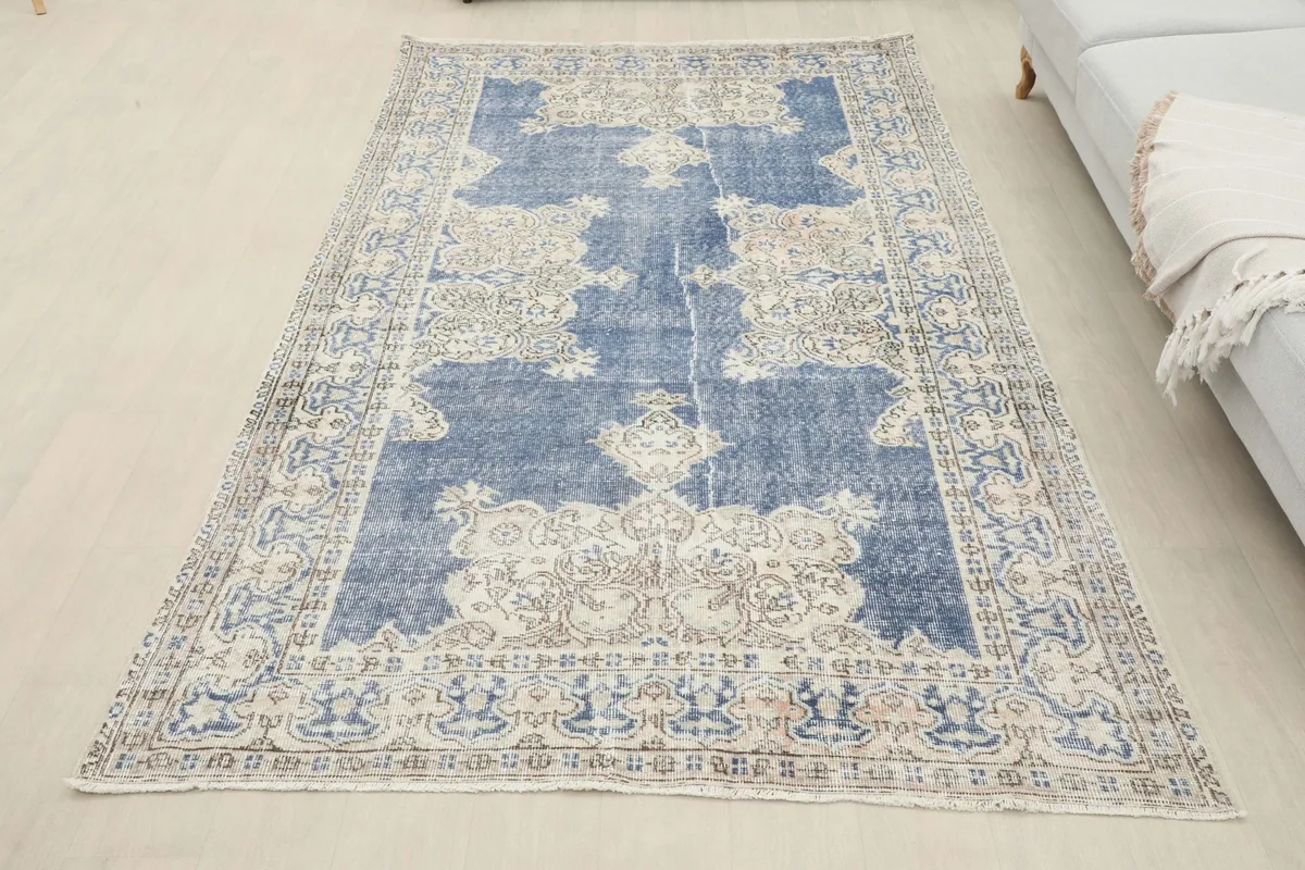 Overhead view of the blue vintage rug laid out on a light-colored floor
