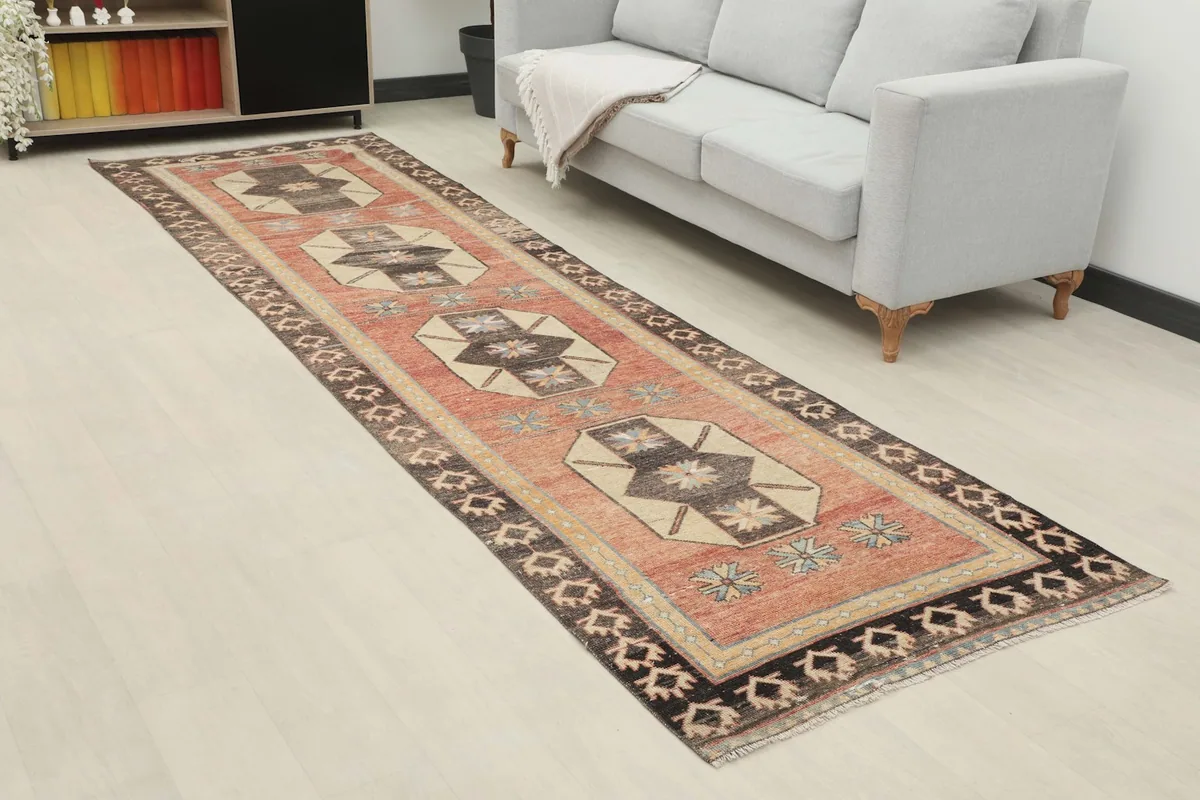 Angled view of the runner rug extending down a hallway next to a sofa and shelving unit