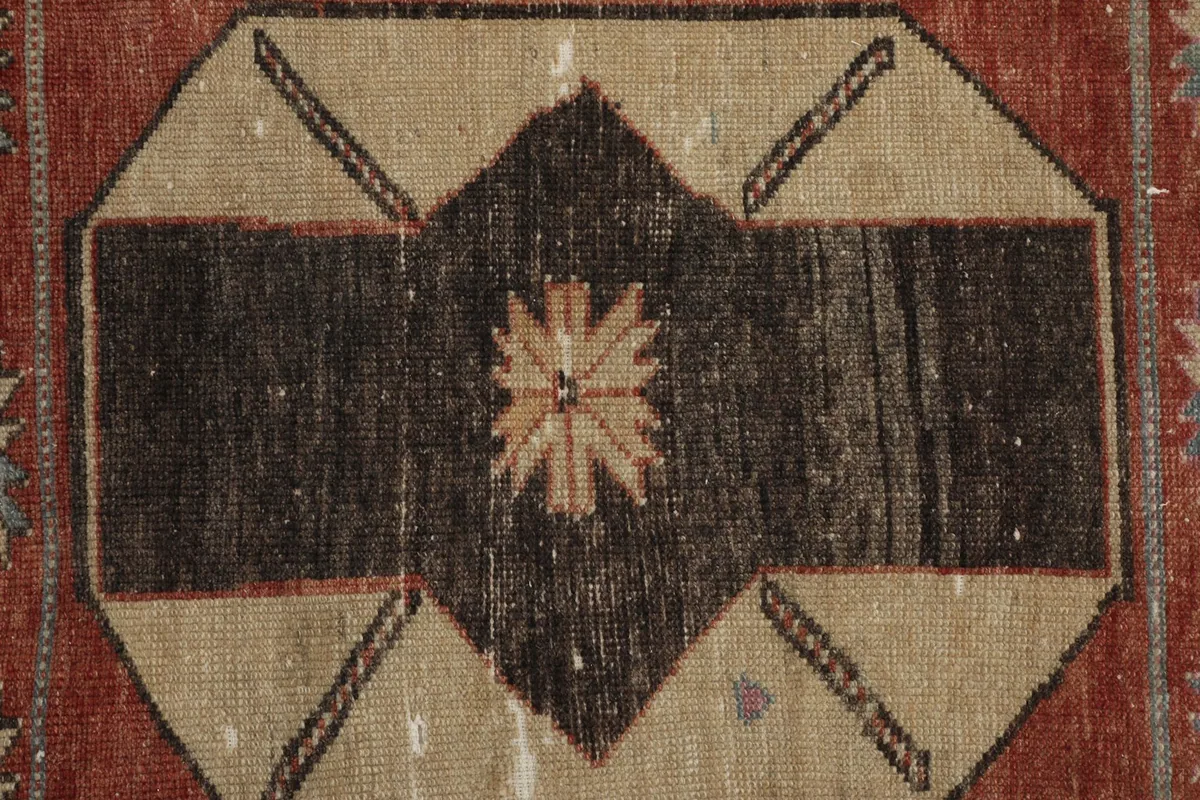 Close-up of a central octagonal motif in beige and black with a star-like center