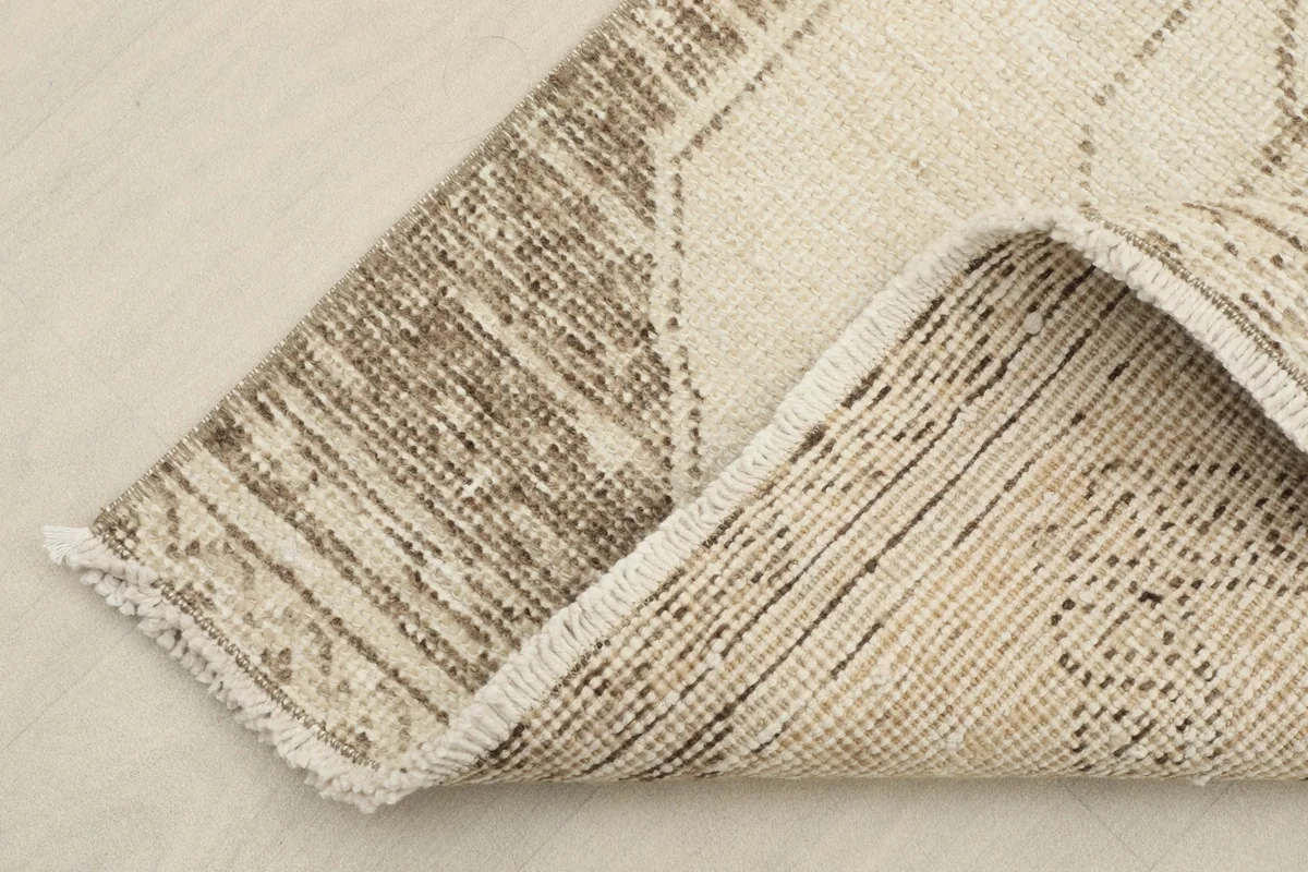 Corner of the rug folded back to reveal the hand-knotted wool pile on cotton foundation