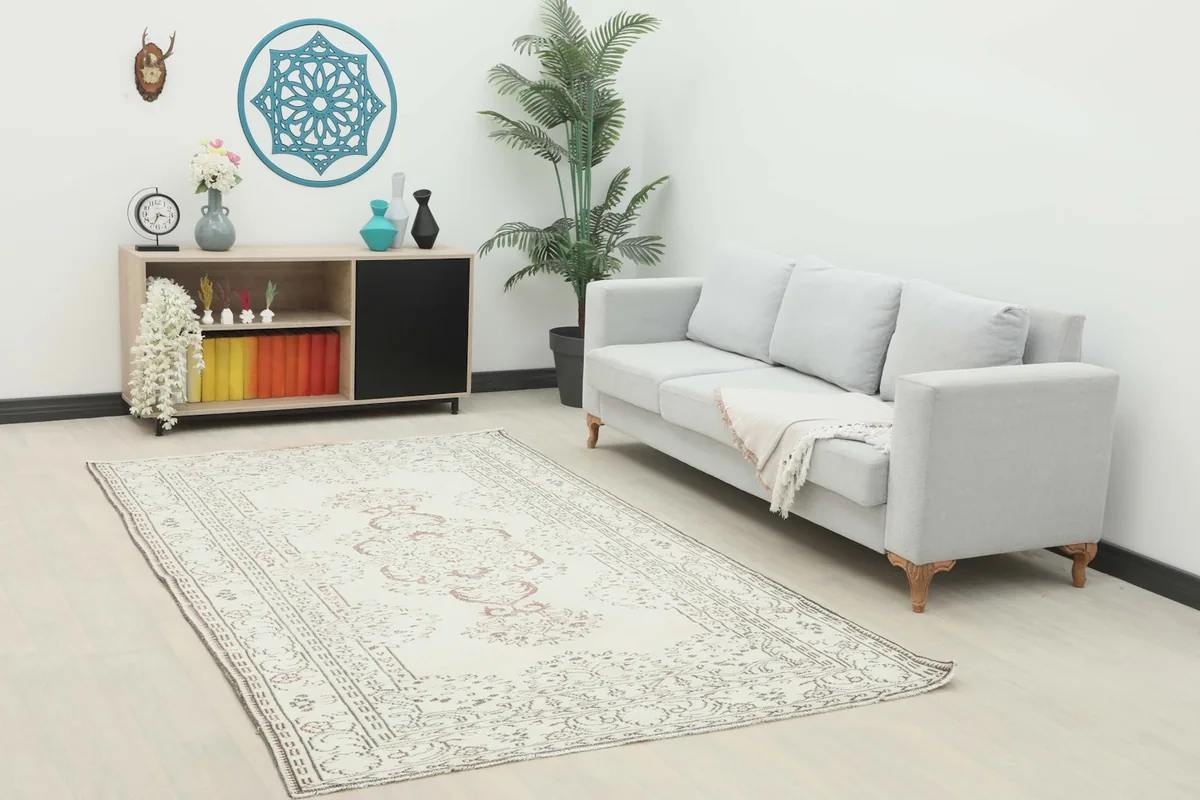 Vintage ivory and rust rug styled in a living room setting with a gray sofa and modern decor.