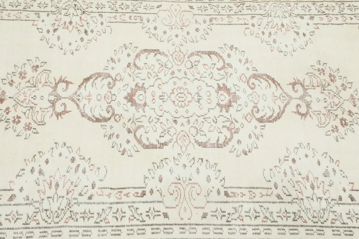 Detailed shot focusing on the central design elements, including the faded rust and brown tones.