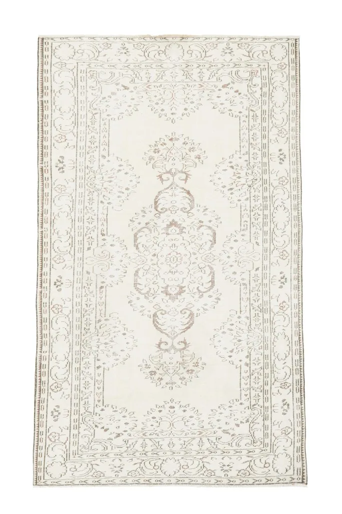 Overhead view showcasing the ivory field, rust medallion, and brown floral patterns of the vintage area rug.