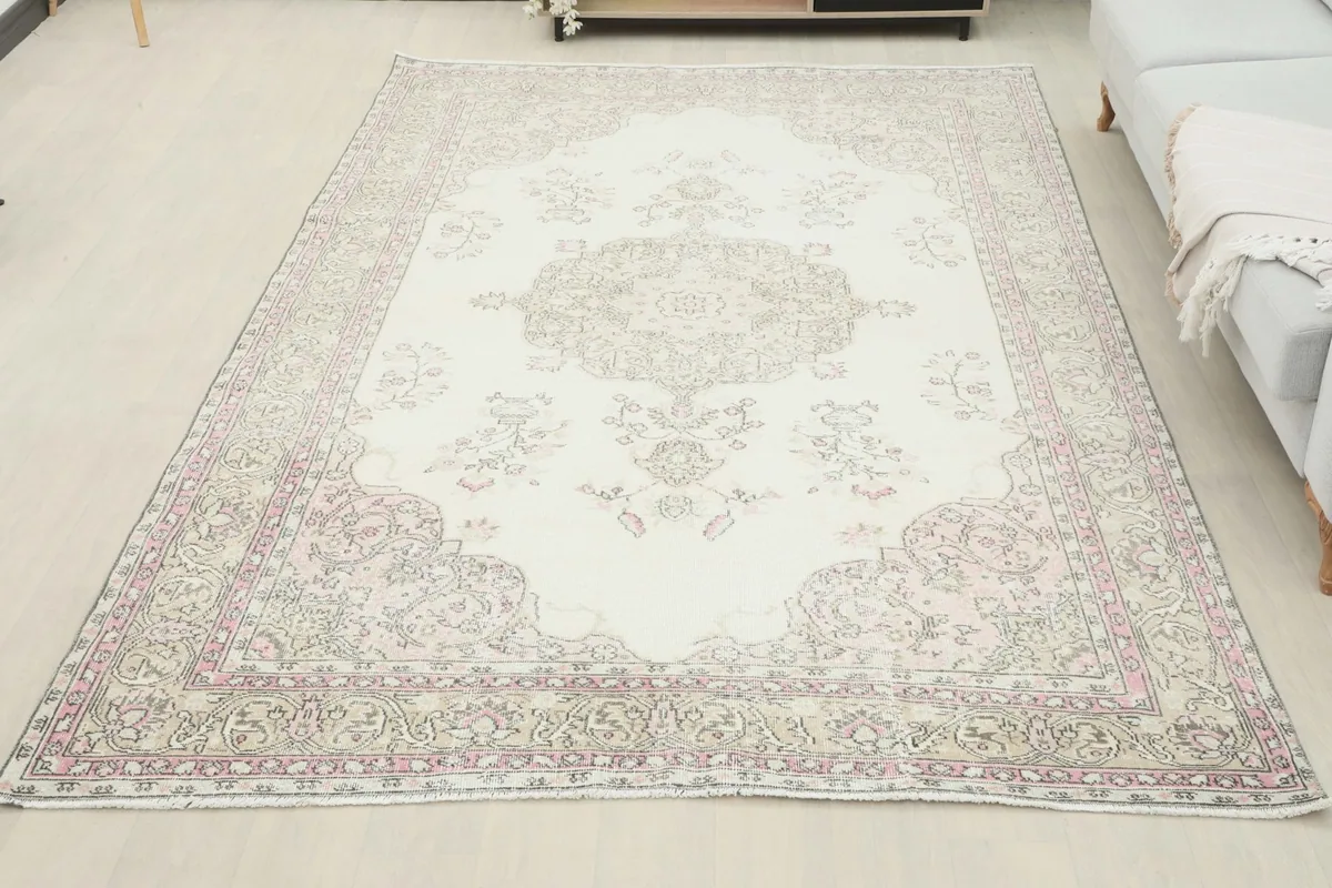 Full view of the ivory pink vintage rug in a room, complementing the light decor