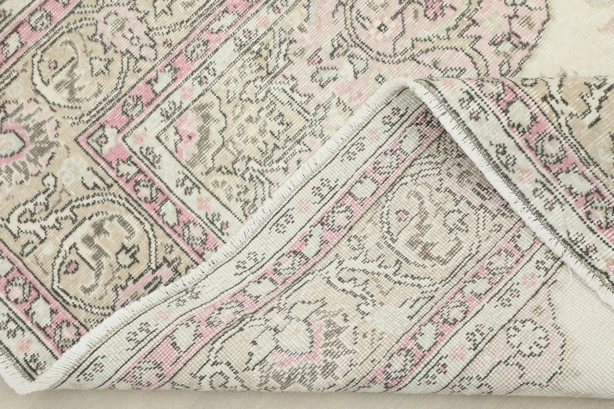 Corner of the rug folded to reveal the backside and knotting detail