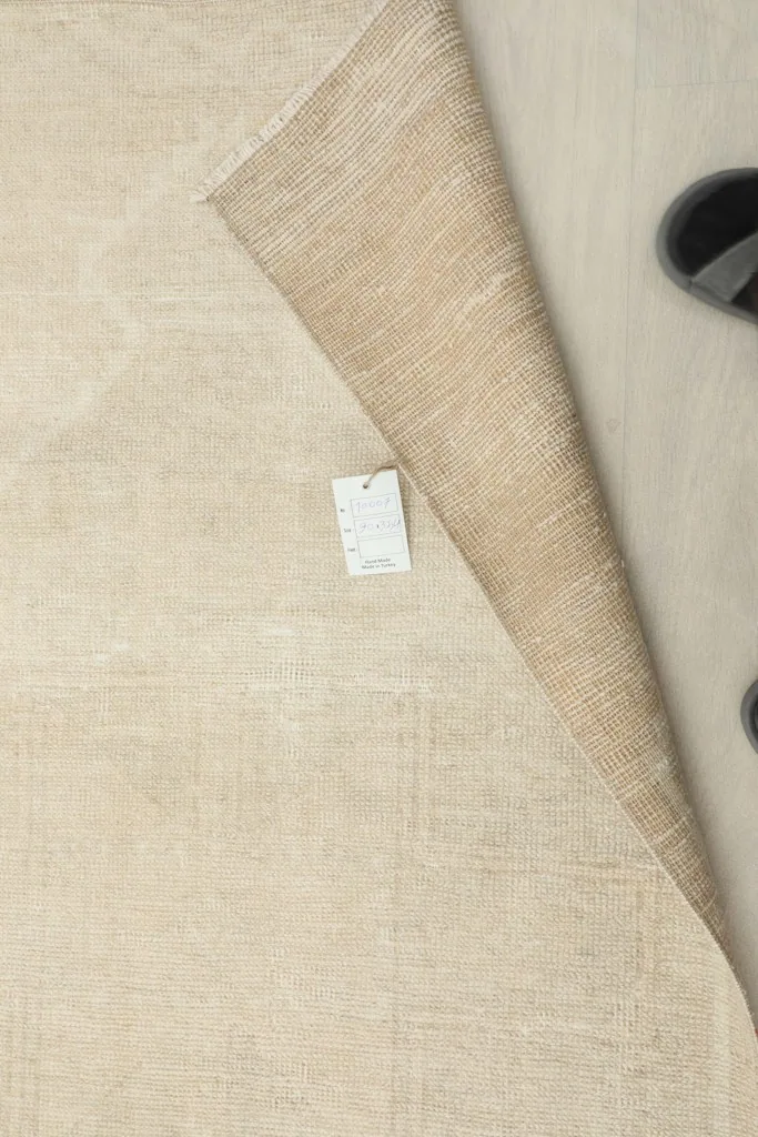 Close-up of the rug's label on the back, with the rug folded to show the foundation.