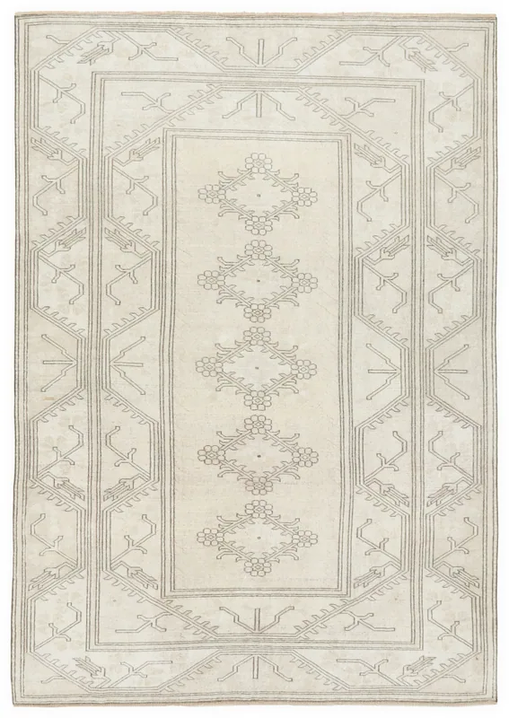 Full overhead view of a 6'3" x 9'1" cream and gray Anatolian vintage area rug on a white background.