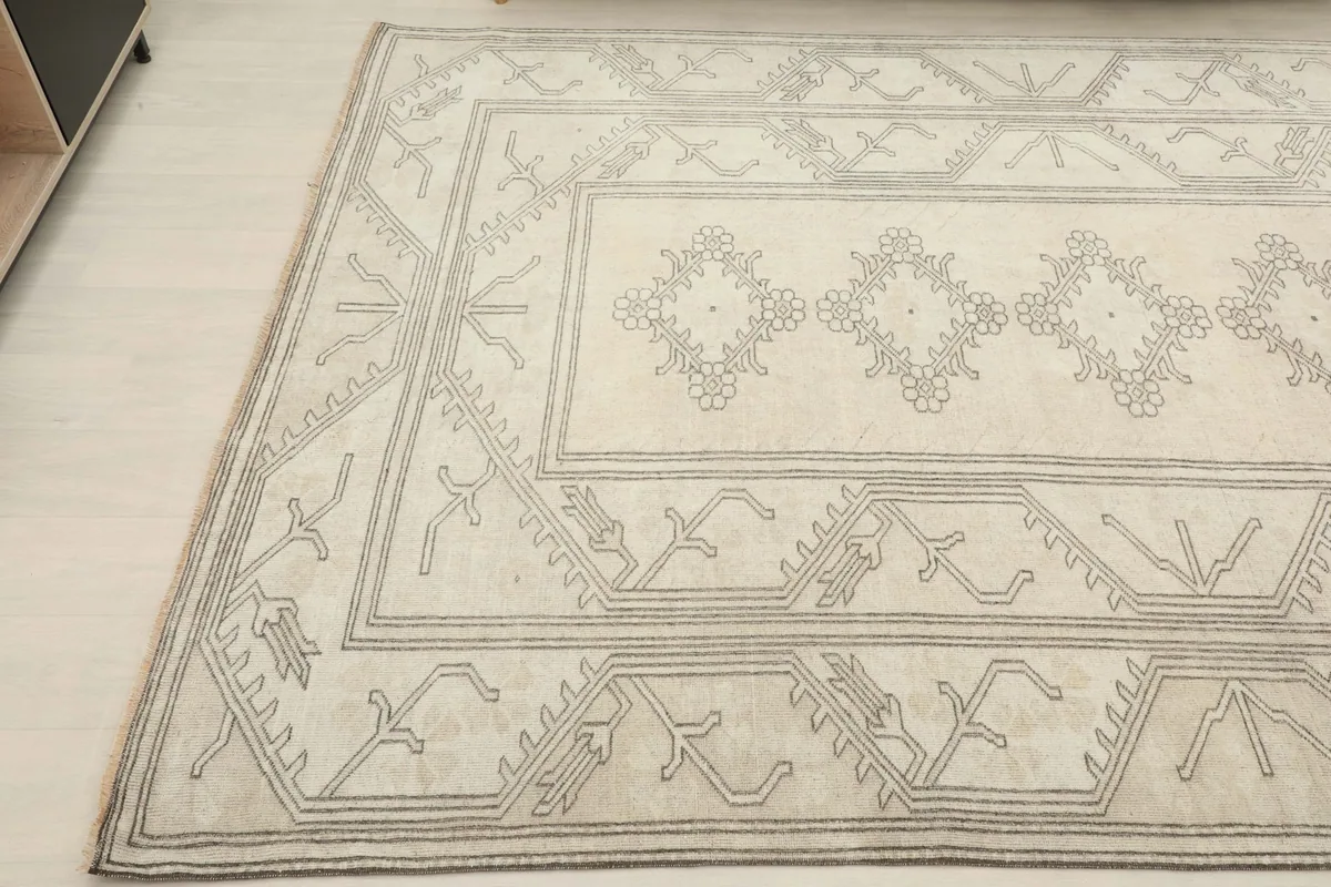 Angled view focusing on the side border and the central cream field with its stylized floral motifs.