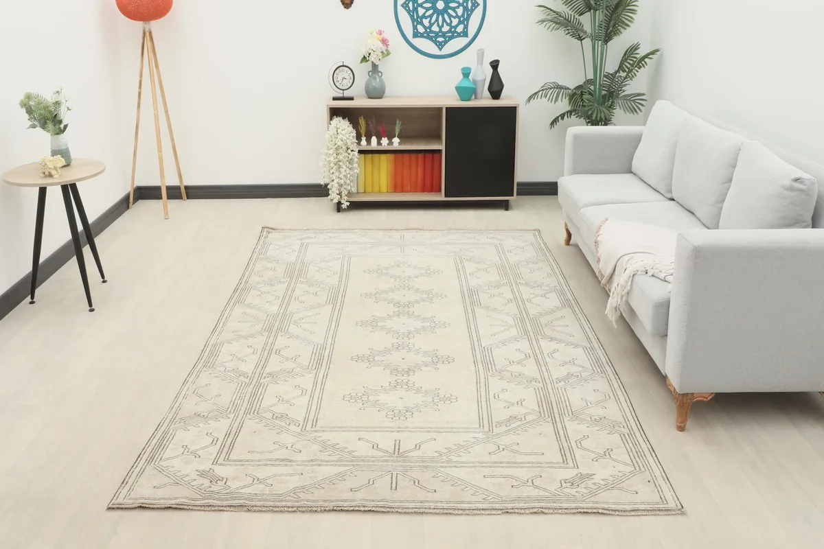 Full room view of the 6'3" x 9'1" cream and gray vintage rug, demonstrating its scale and aesthetic impact.
