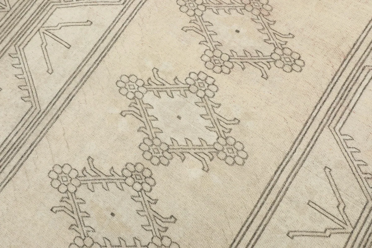 Detailed close-up of the central stylized floral diamond motifs against the cream background.