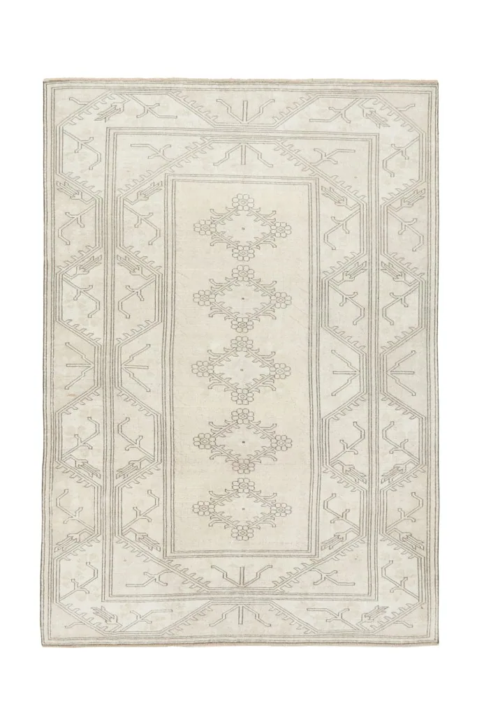 Full overhead view of the cream and gray vintage rug, showcasing its geometric and tribal patterns.