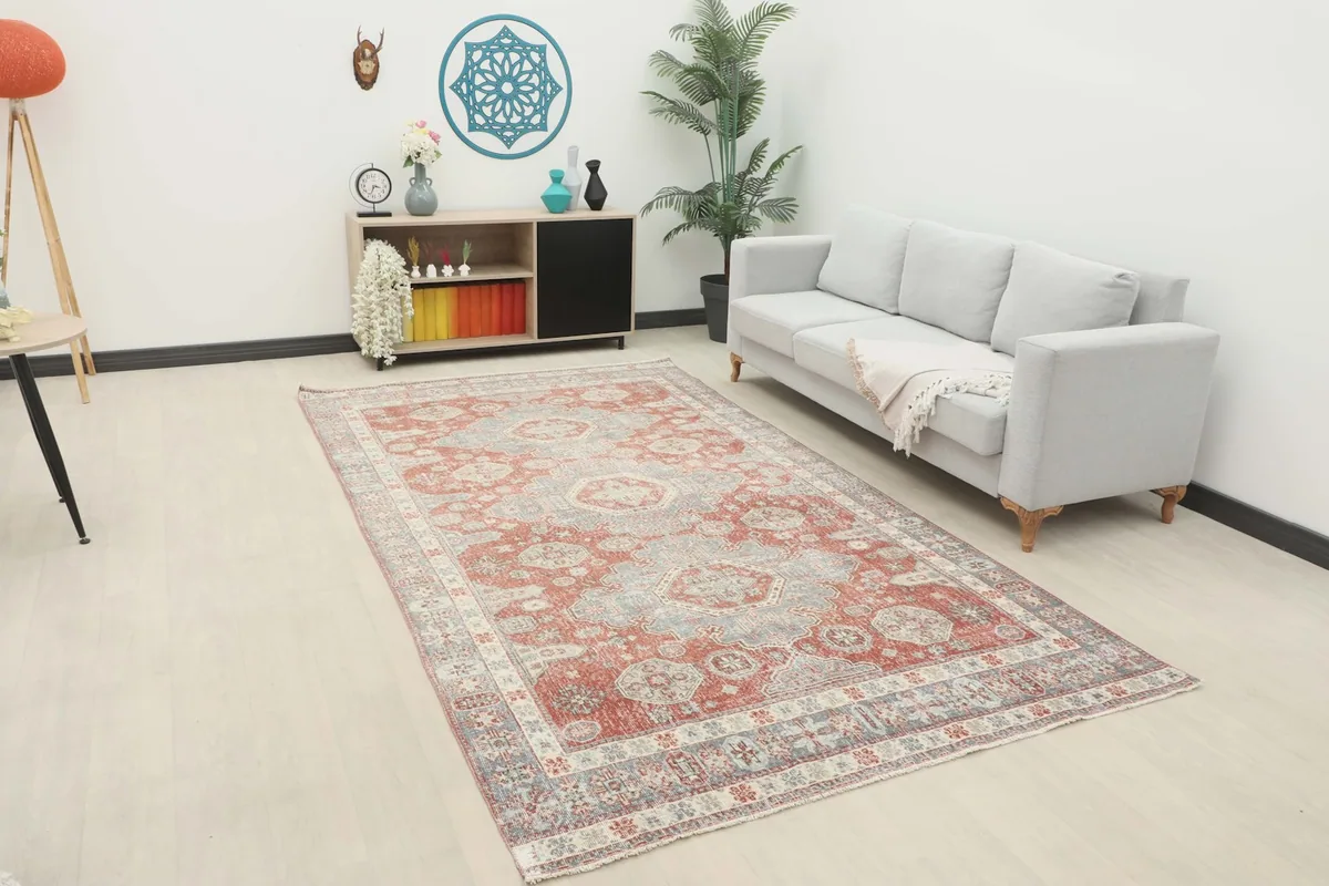 Vintage Anatolian rug displayed in a living room setting with a light gray sofa