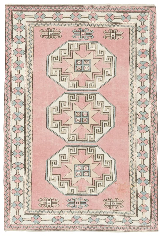 Full overhead view of the pink geometric Anatolian area rug on a white background