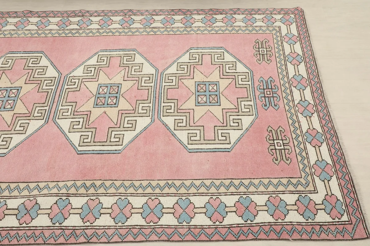 Close-up of the rug's top right corner, showing geometric patterns and border design
