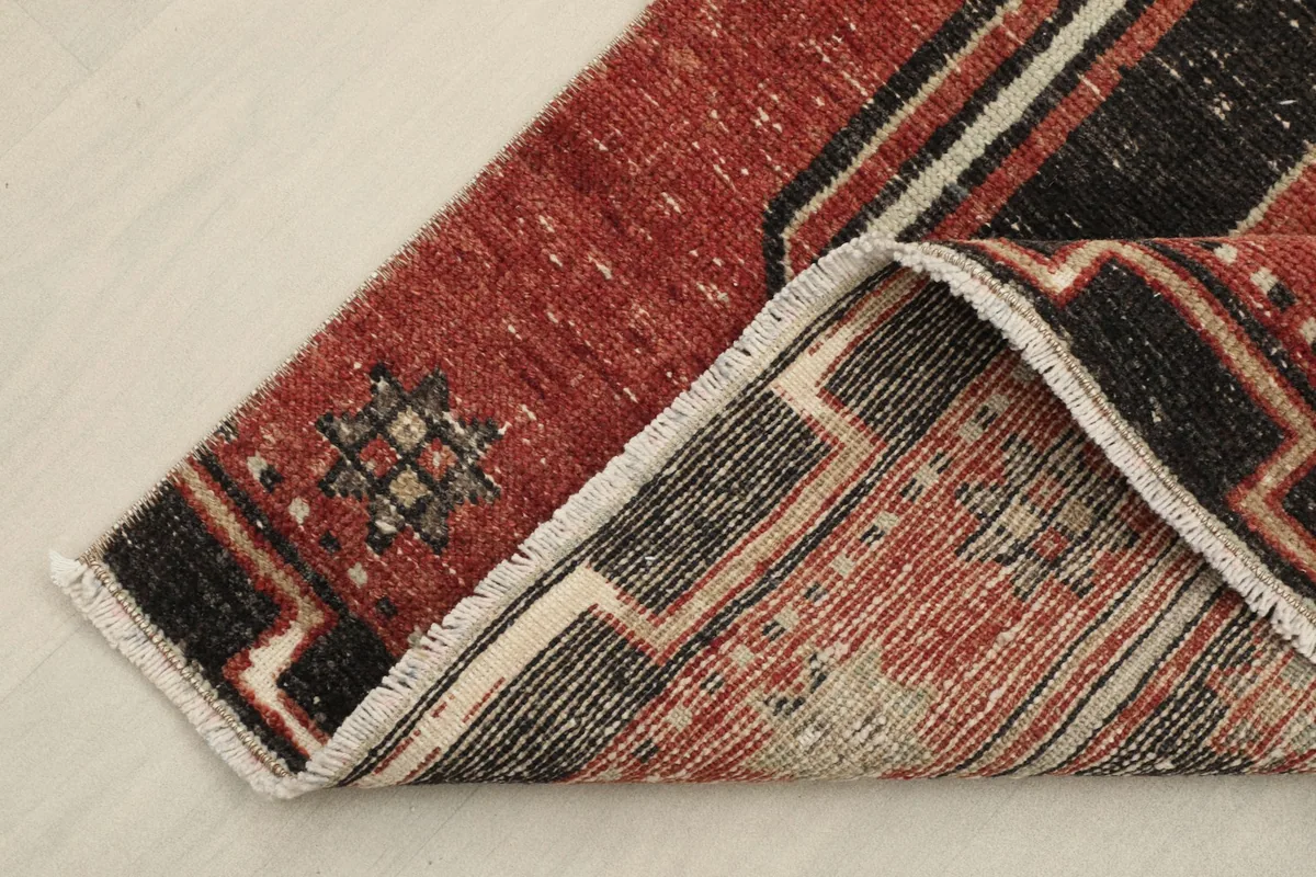 View of the underside and a folded corner of the hand-knotted wool pile on cotton foundation runner rug.