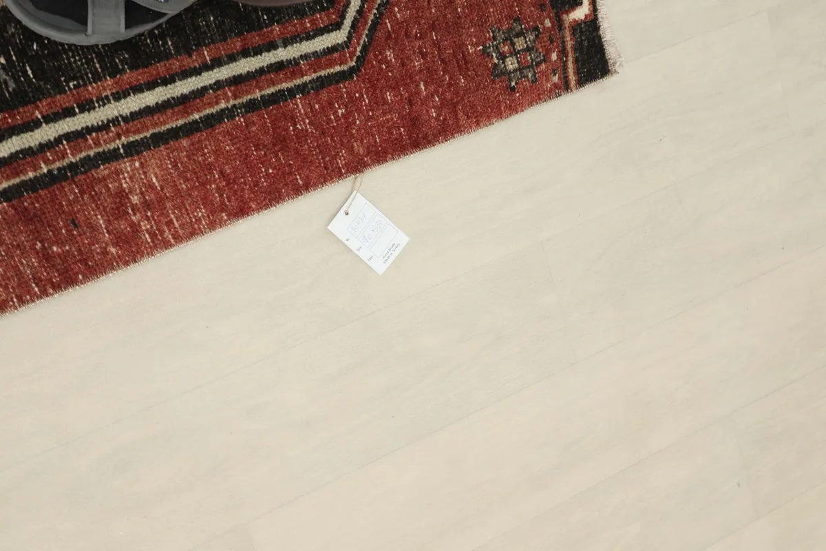 Overhead view of a section of the runner rug with a product tag, showing the rust and black colors.