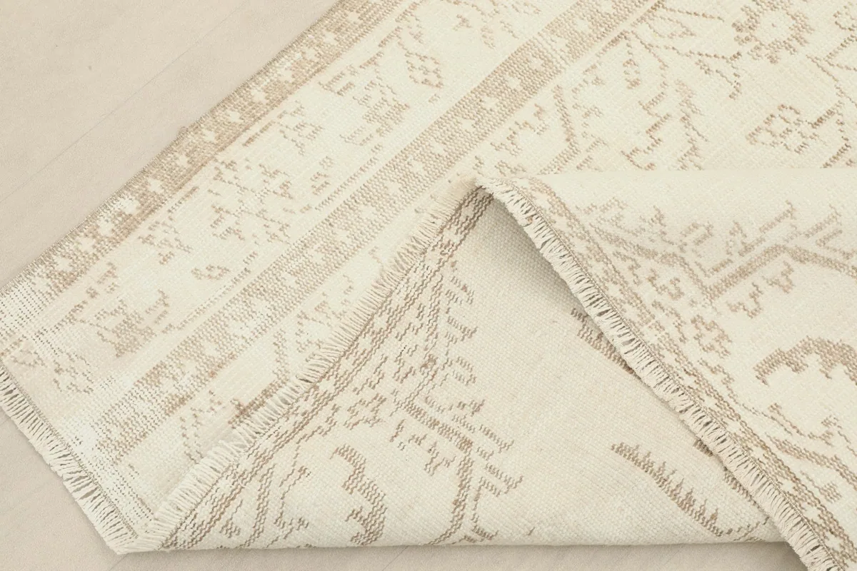 View of the rug folded back to show the reverse side and the hand-knotted construction.