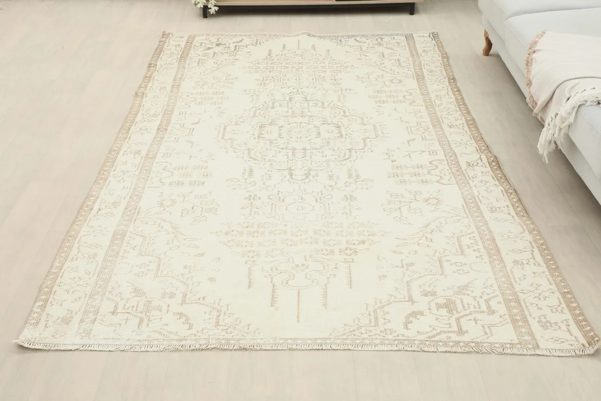 Full overhead view of the cream and tan vintage rug laid out in a room setting.