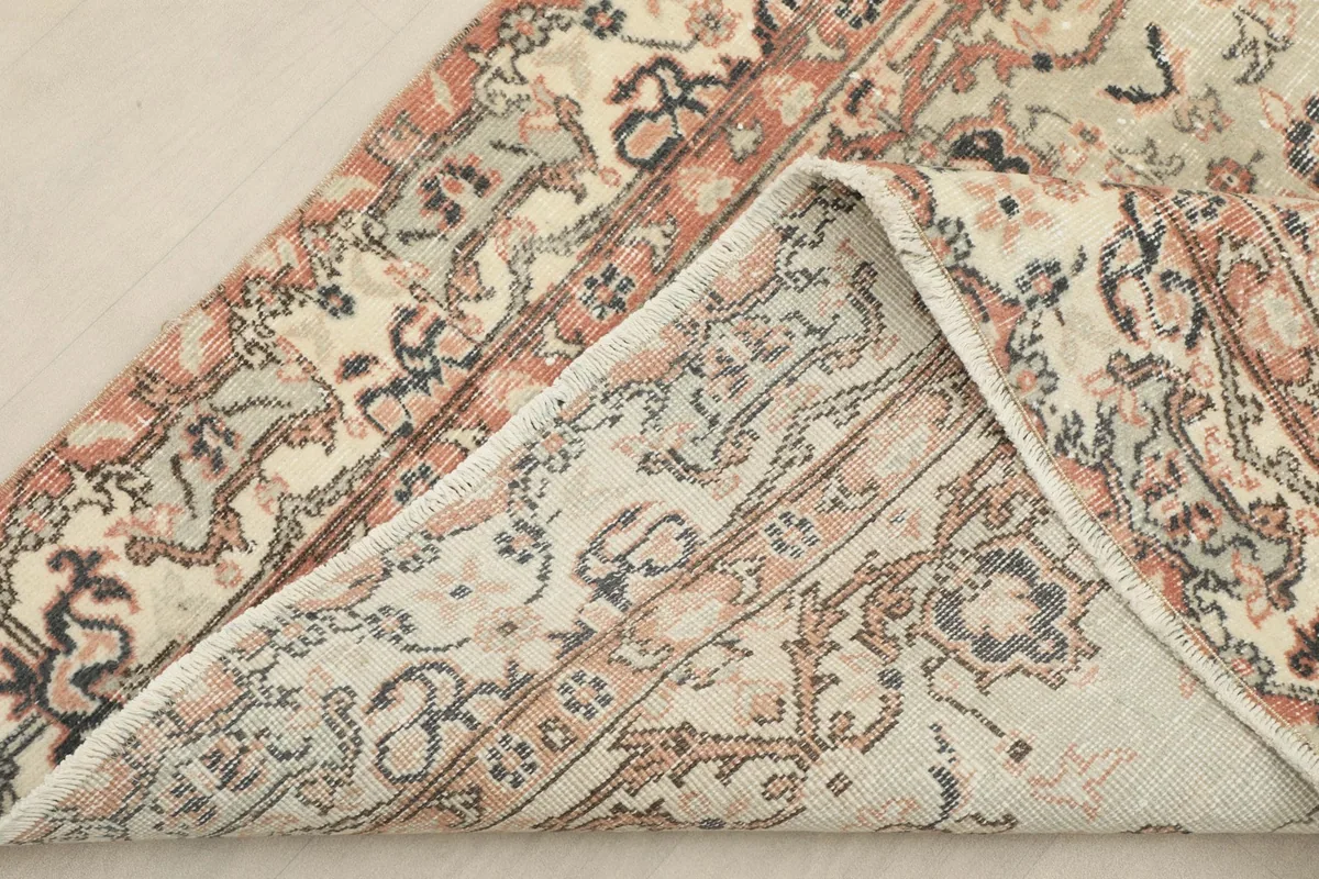 View showing the back of the rug and a corner folded over, illustrating the cotton foundation.