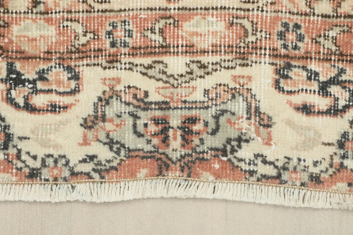 Detail of the rug's fringe and the intricate patterns along the edge.