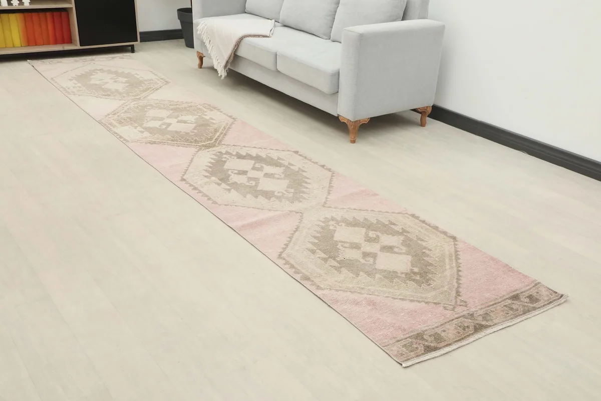 Long view of the rose and beige geometric runner in a room, highlighting its length and pattern flow.