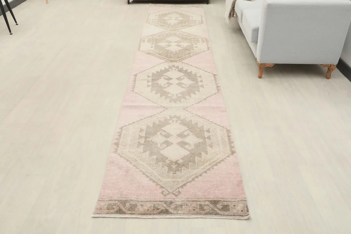 Full overhead view of the rose and beige geometric Anatolian runner, showcasing its entire design on a light floor.