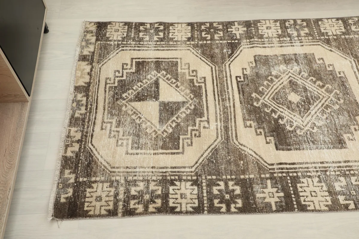 Close-up angled view of two geometric medallions and the border design on the runner rug.