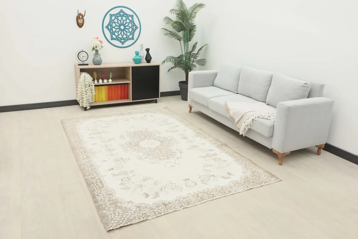Vintage Anatolian rug with ivory and tan floral medallion in a modern living room setting