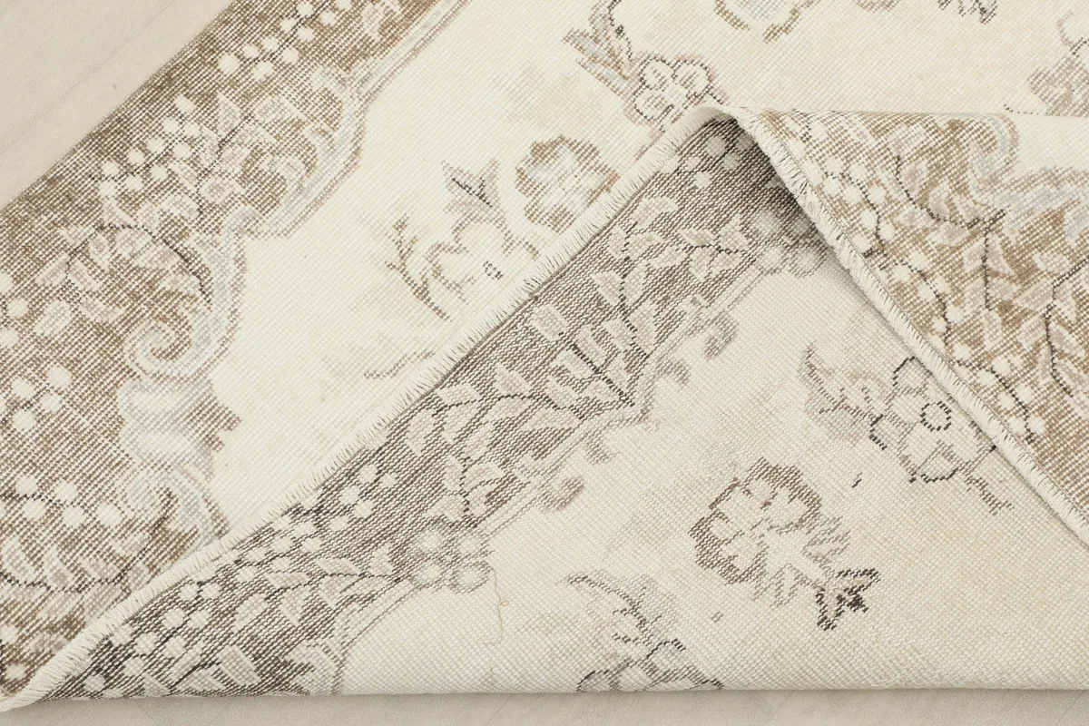 Folded corner of the rug showing the cotton foundation and wool pile