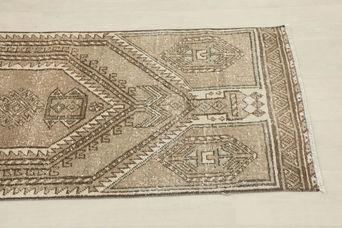 Close-up of one end of the runner rug, highlighting the geometric patterns and border design.