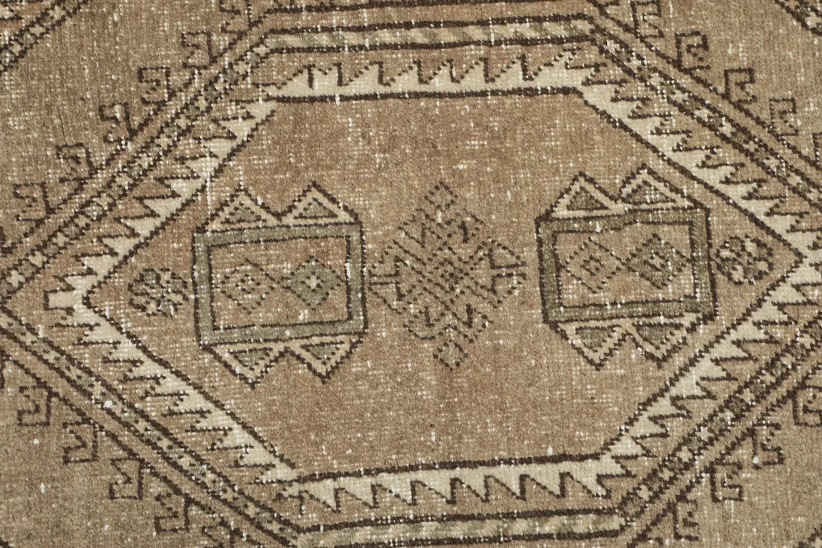 Tight close-up of the rug's surface, revealing the hand-knotted texture and worn patina.
