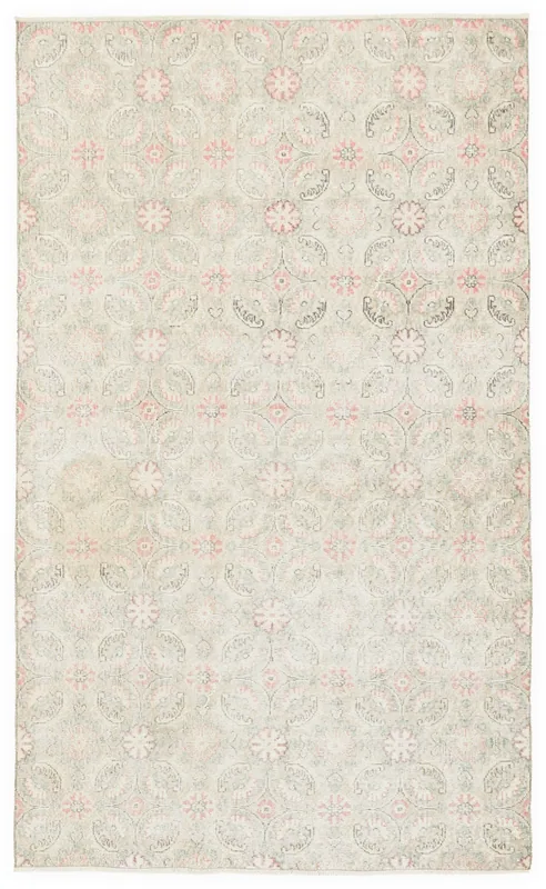 Full top view of the vintage beige and pink floral Anatolian rug on a white background.