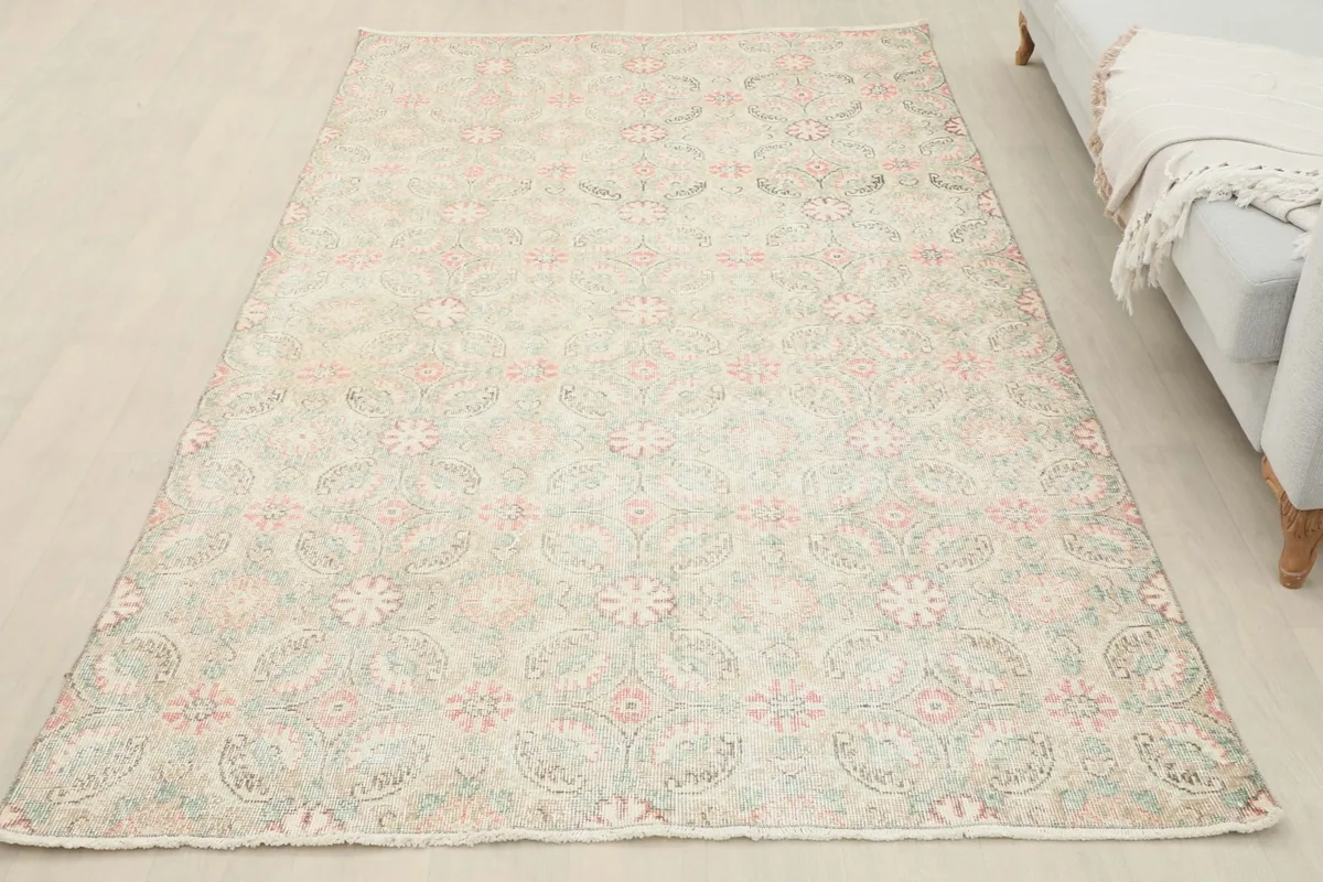 Overhead view of the beige, pink, and green vintage Anatolian rug in a room, illustrating its full size.