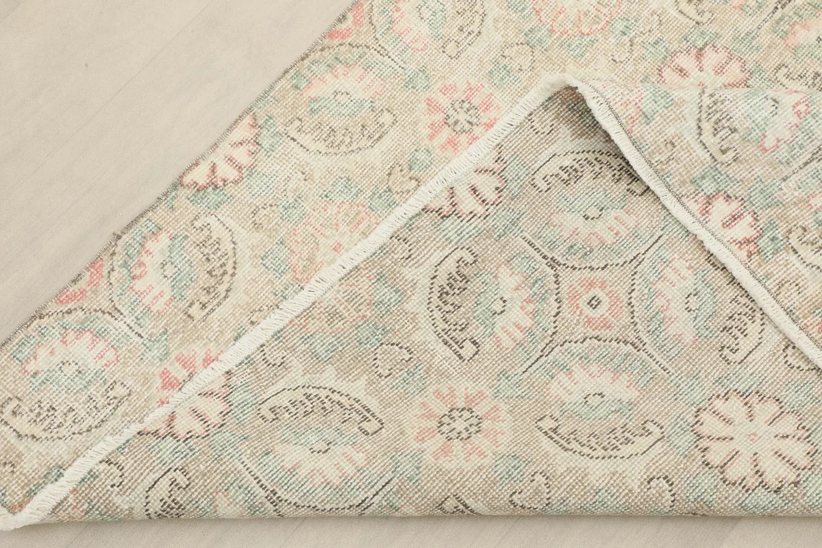View of the rug's underside, revealing the cotton foundation and the reverse of the hand-knotted pattern.