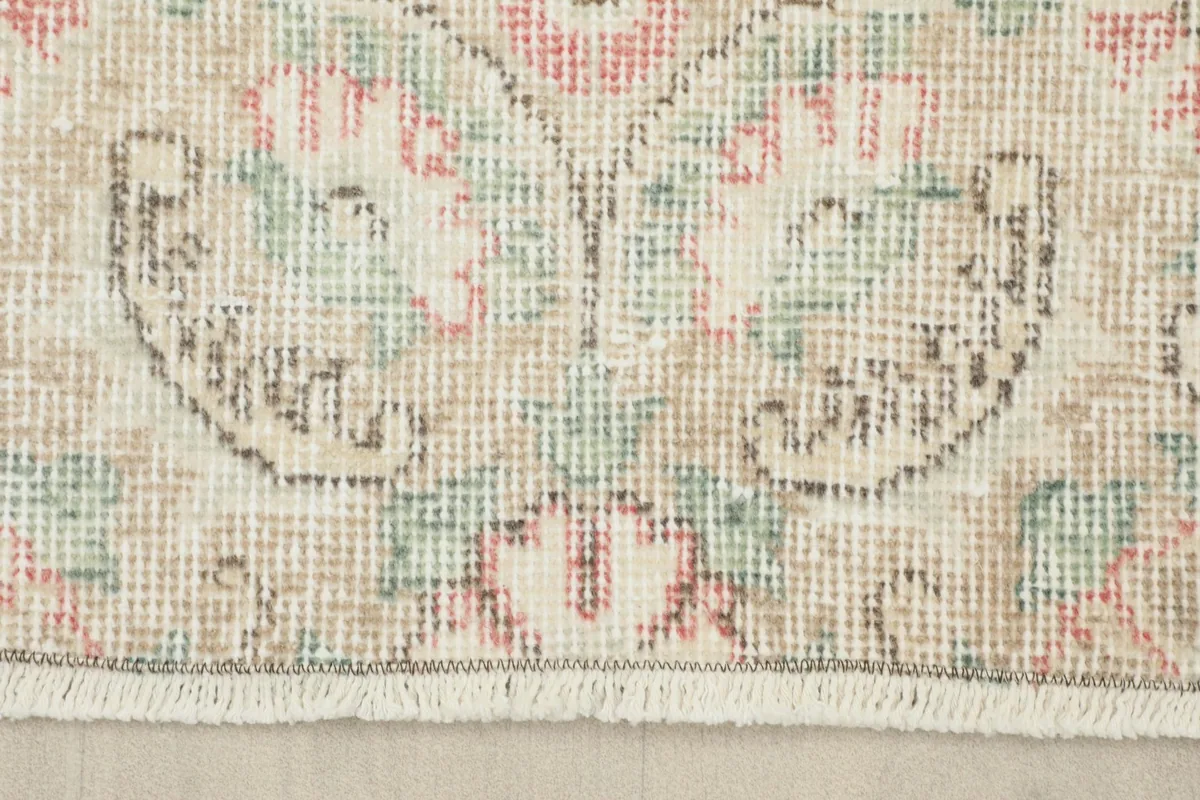 Close-up of the rug's natural fringe and the finished edge, showing the texture of the wool.