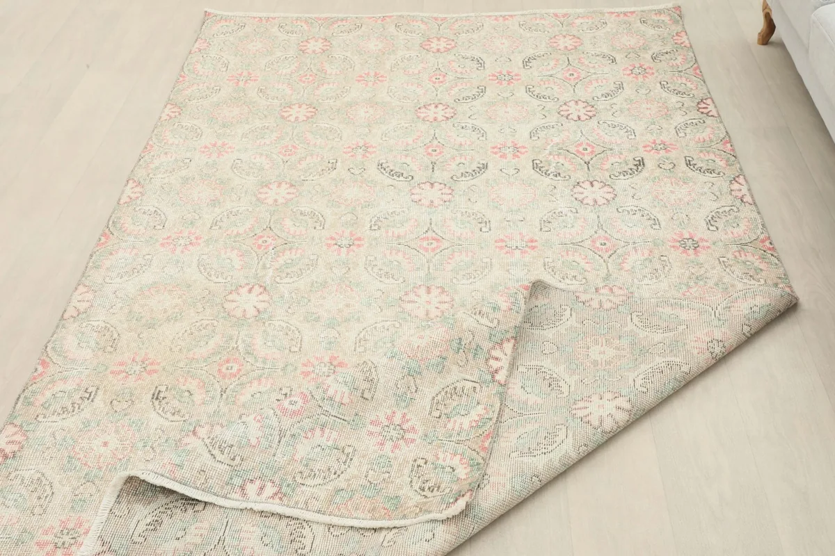 The vintage rug folded back to show the thickness and flexibility of the hand-knotted construction.