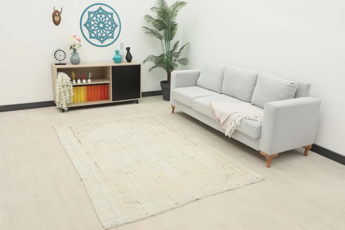 Ivory vintage rug placed in a living room setting with a light gray sofa