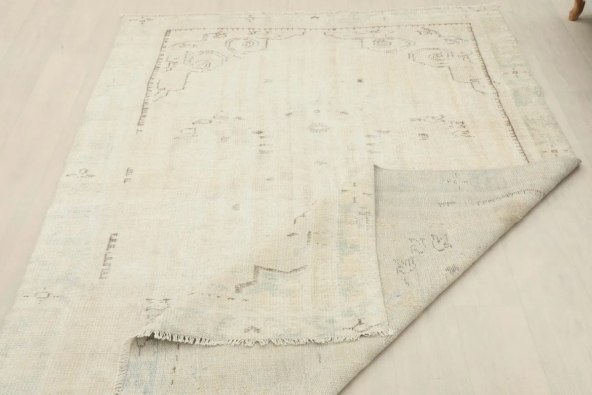 Overhead view of the rug with a corner folded to reveal the backside and knotting