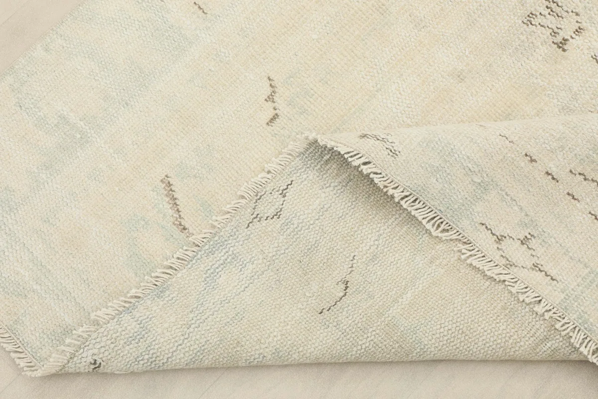 View of the rug folded back, showing the cotton foundation and reverse side