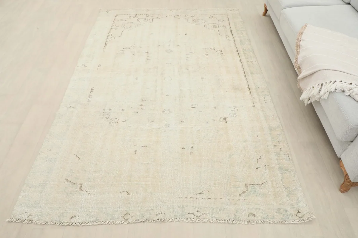 Overhead view of the ivory vintage rug in a room setting next to a sofa