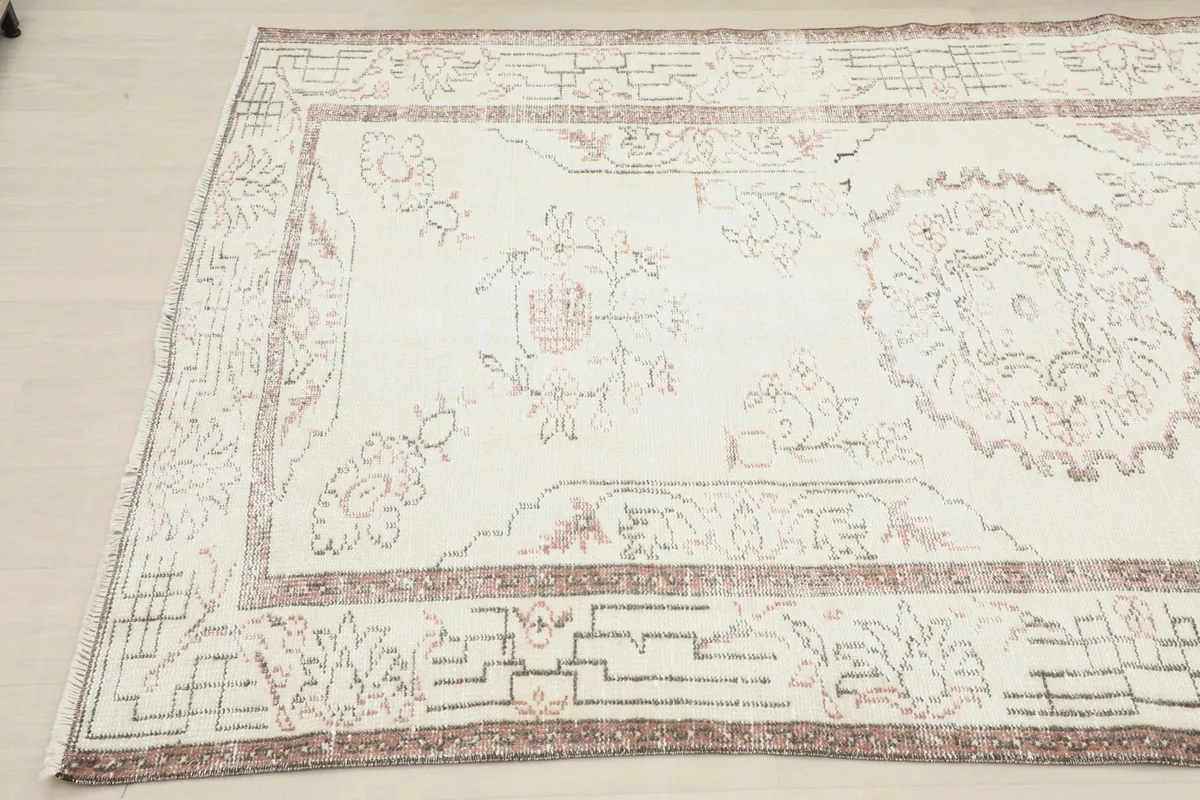 Close-up angled view of the rug's patterns and border on the left side
