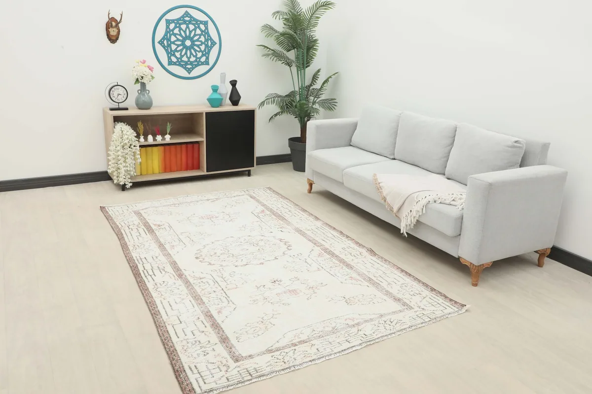 Ivory vintage rug placed in a modern living room setting with a light gray sofa